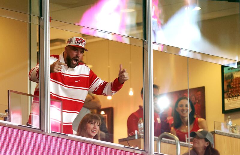 Travis Kelce of the Kansas City Chiefs reacts as fiancee Taylor Swift smiles while watching from a suite during the second half of the game between the Cincinnati Bearcats and the Nebraska Cornhuskers at Arrowhead Stadium on August 28, 2025 in Kansas City, Missouri.