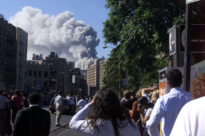 People watch as the second of two World Trade Center towers collapses after planes crashed into the buildings, in New York on September 11, 2001.