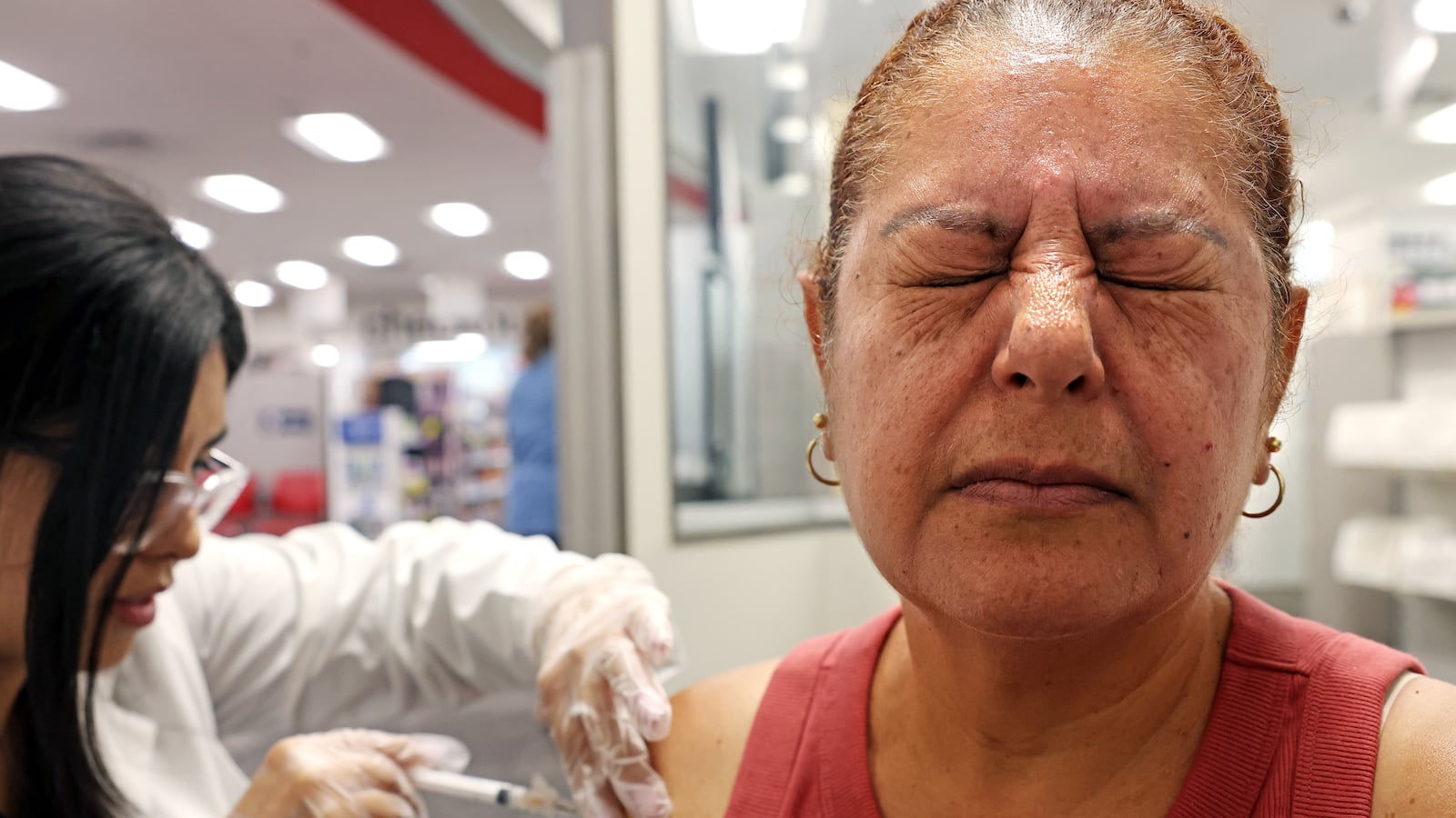 HUNTINGTON PARK-CA-AUGUST 28, 2024: Elizabeth Gomez, 54, of Huntington Park, right, receives a Prevnar and shingles vaccine by pharmacy manager Sandra Gonzalez at CVS in Huntington Park on August 28, 2024. (Christina House / Los Angeles Times via Getty Images)