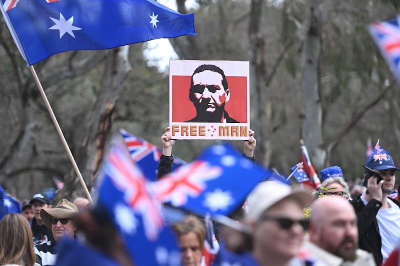 A man holds a placard with an image of fugitive Dezi Freeman at anti-immigration protesters march from Rundle Park on August 31, 2025 in Adelaide, Australia.