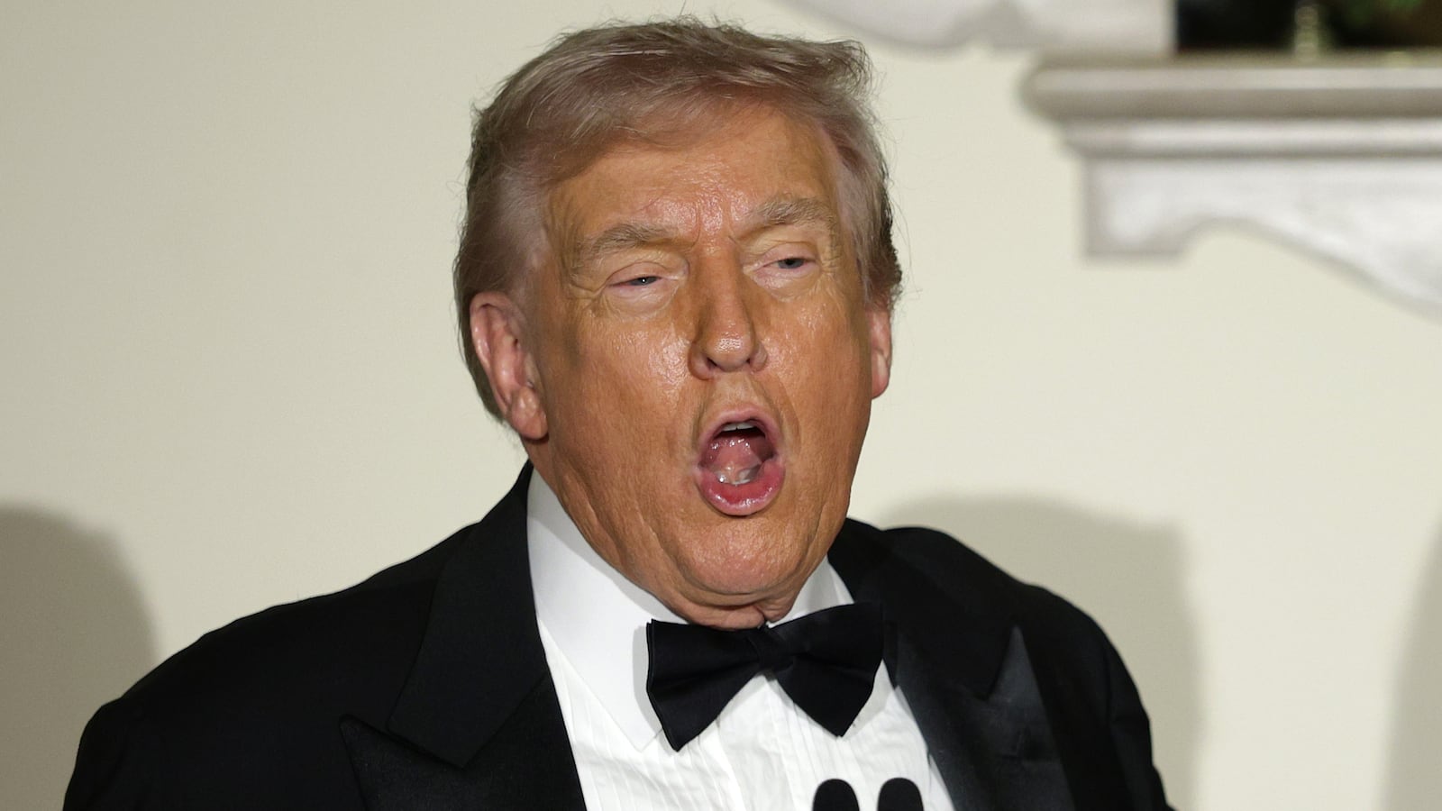 U.S. President Donald Trump delivers remarks as first lady Melania Trump looks during the Congressional Ball at the Grand Foyer of the White House on December 11, 2025 in Washington, DC.