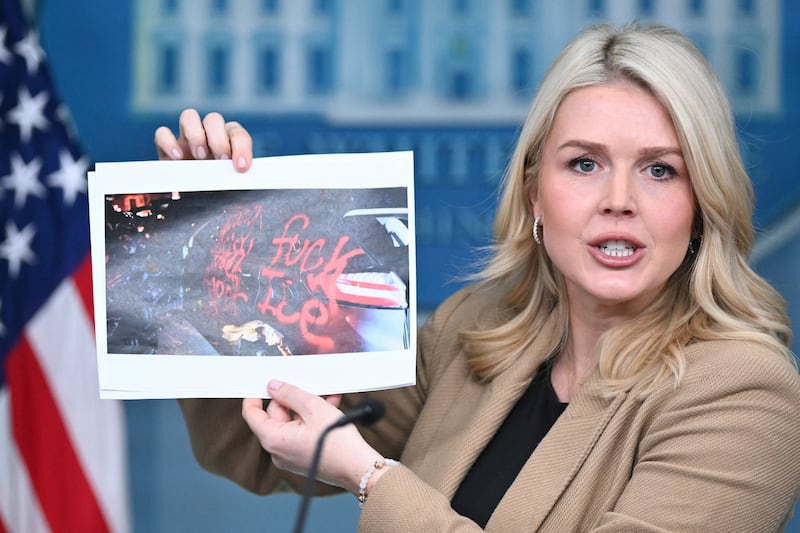 White House Press Secretary Karoline Leavitt holds up a picture of allgedly vandalized ICE vehicles in Minnesota as she speaks during a press briefing at the White House in Washington, DC, on January 15, 2026.