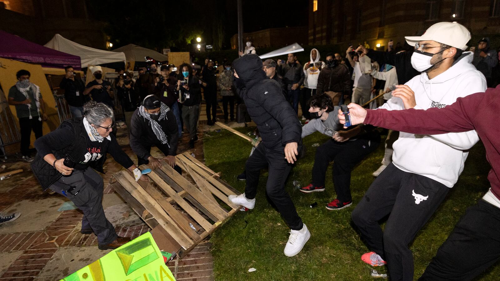 Counter protesters attack pro-Palestinian protesters at a pro-Palestinian encampment set up on the campus of the University of California Los Angeles (UCLA) as clashes erupt, in Los Angeles on May 1, 2024.