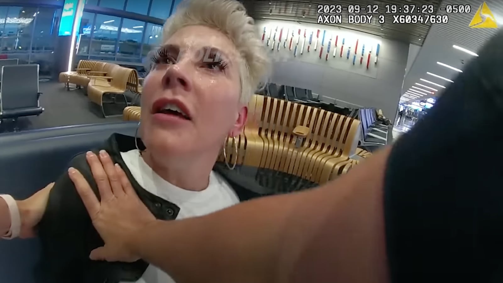 New footage shows that as she was marched away from her gate, the drunken passenger mocked the arresting officers, and wet herself.