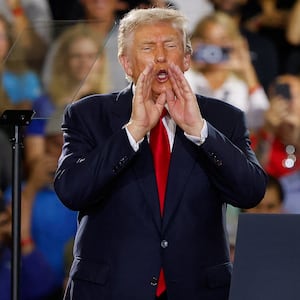 U.S. President Donald Trump puts his hands to his face, as he delivers remarks on the economy, at the General Motors Proving Ground in Milford, Michigan, U.S. July 27, 2026.  REUTERS/Carlos Osorio