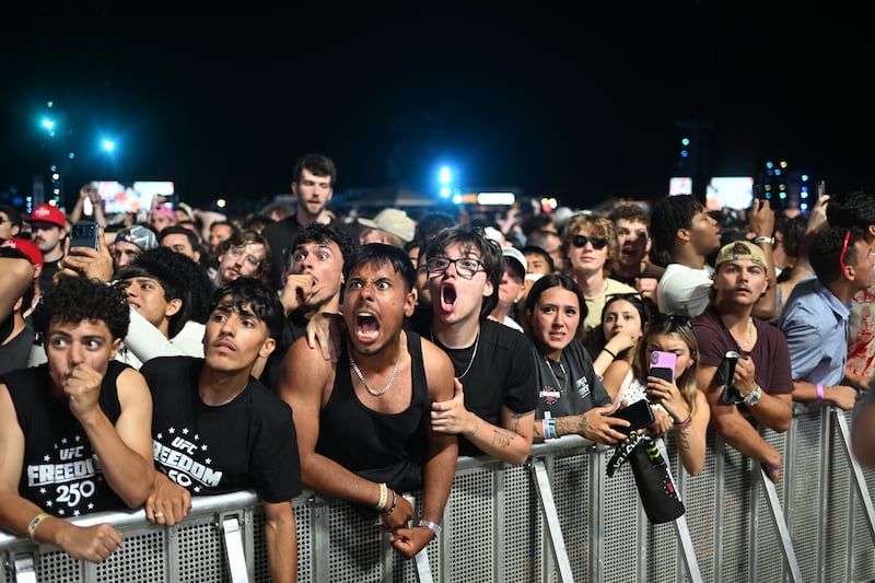 TOPSHOT - Fans react as they watch the "UFC Freedom 250" mixed martial arts event on The Ellipse, south of the White House in Washington, DC, June 14, 2026. (Photo by Alex WROBLEWSKI / AFP via Getty Images)