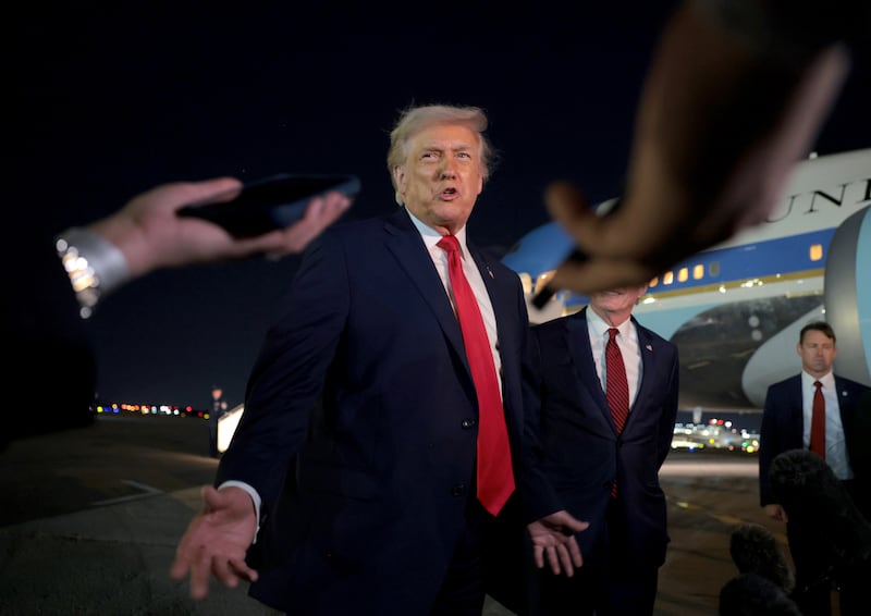 U.S. President Donald Trump talks with reporters on the tarmac at Palm Beach International Airport.