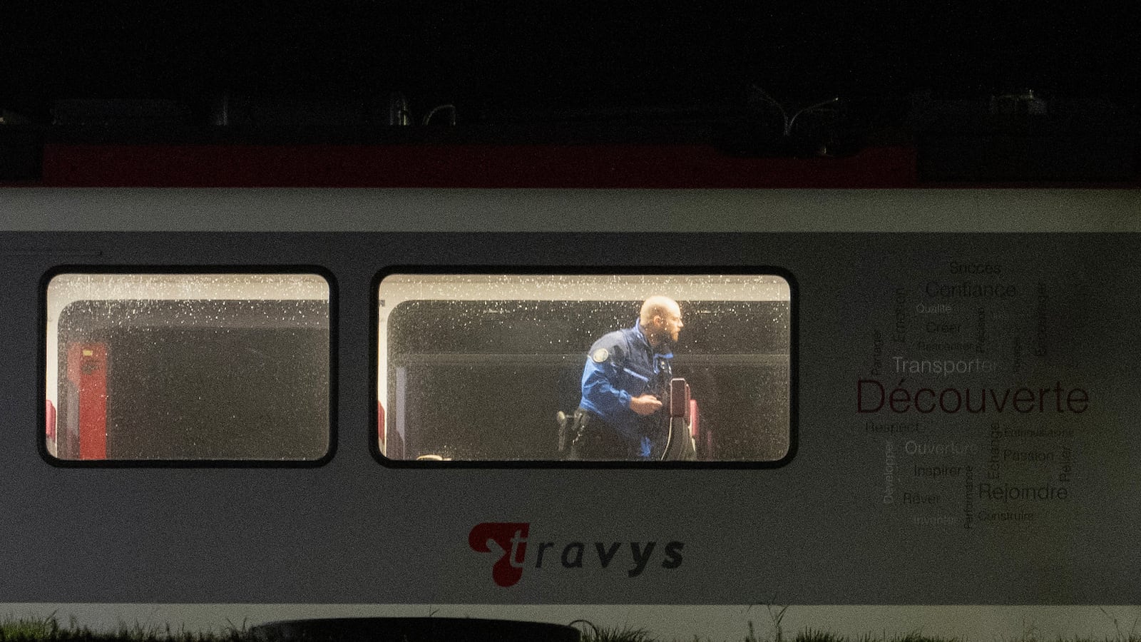 A Swiss Gendarme Police officer inspects the inside of a train, where passengers travelling from Yverdon to Sainte-Croix were earlier held hostage