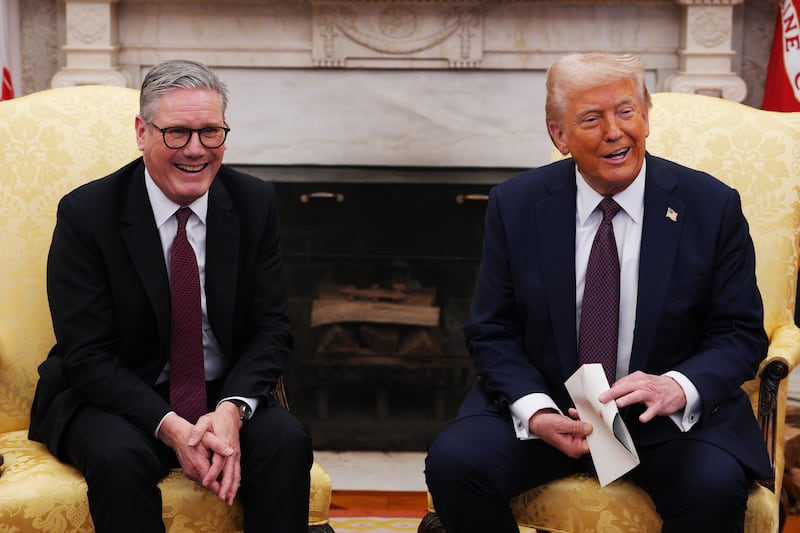 UK Prime Minister Sir Keir Starmer hands an invitation from King Charles III for a second state visit to U.S. President Donald Trump at the White House on February 27, 2025 in Washington, DC.