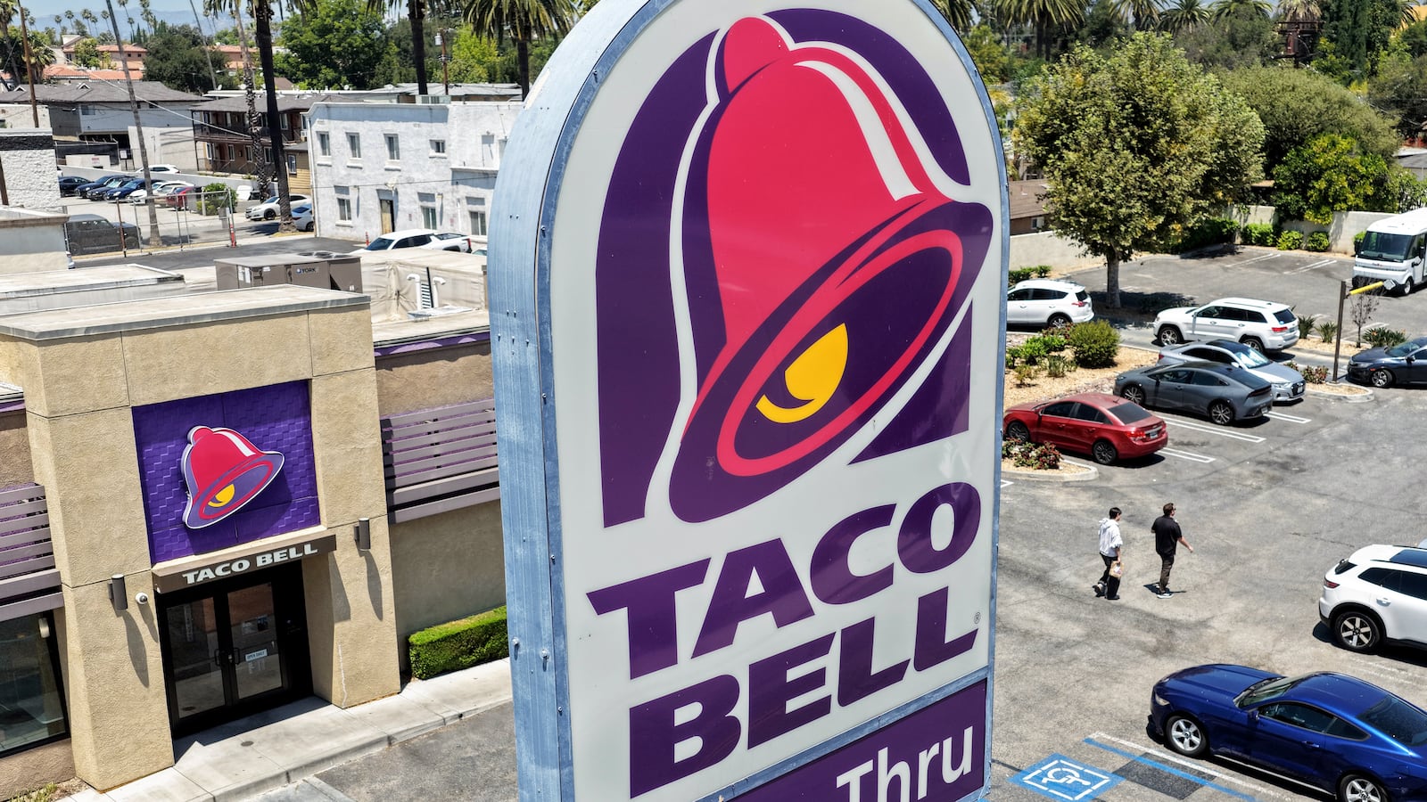 PASADENA, CALIFORNIA - JULY 14: In an aerial view, customers depart a Taco Bell restaurant on July 14, 2026 in Pasadena, California. Federal and state health officials have reportedly begun investigating whether lettuce served at some Taco Bell restaurants has led to the widespread outbreak of cyclosporiasis, a gastrointestinal illness, which has sickened thousands around the country. (Photo by Mario Tama/Getty Images)