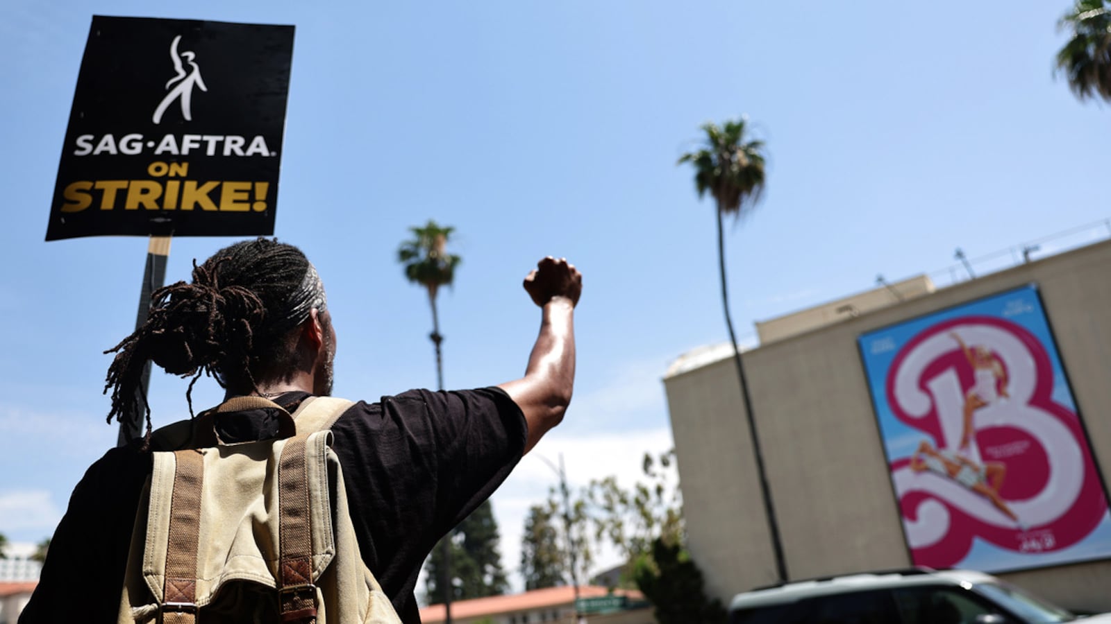 Photograph of man protesting with SAG-AFTRA during the strike in Hollywood in front of a Barbie movie poster