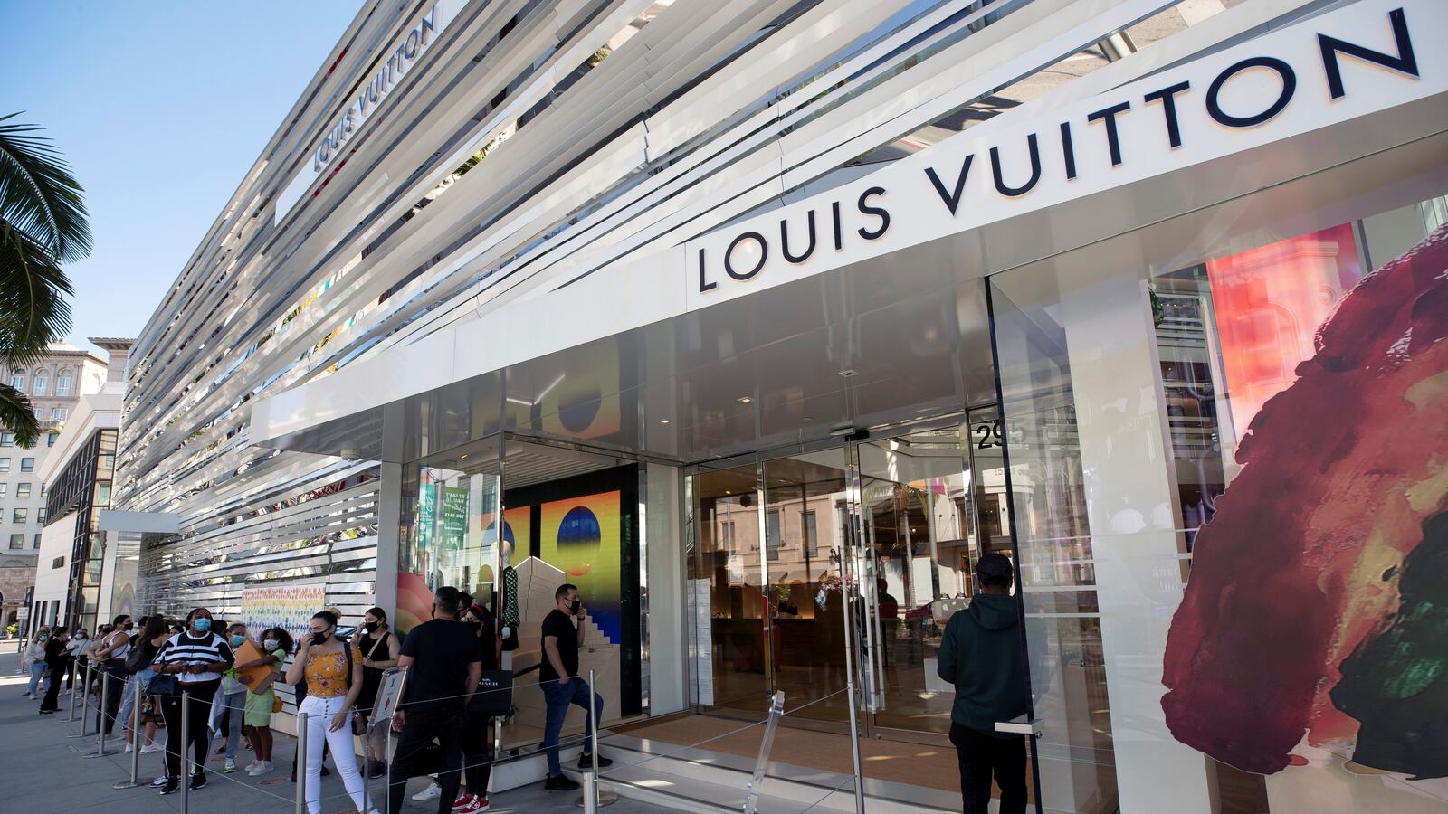 Shoppers stand in line wearing face masks outside the Louis Vuitton store during the outbreak of the coronavirus disease (COVID-19), in Beverly Hills, California, July 30, 2020.