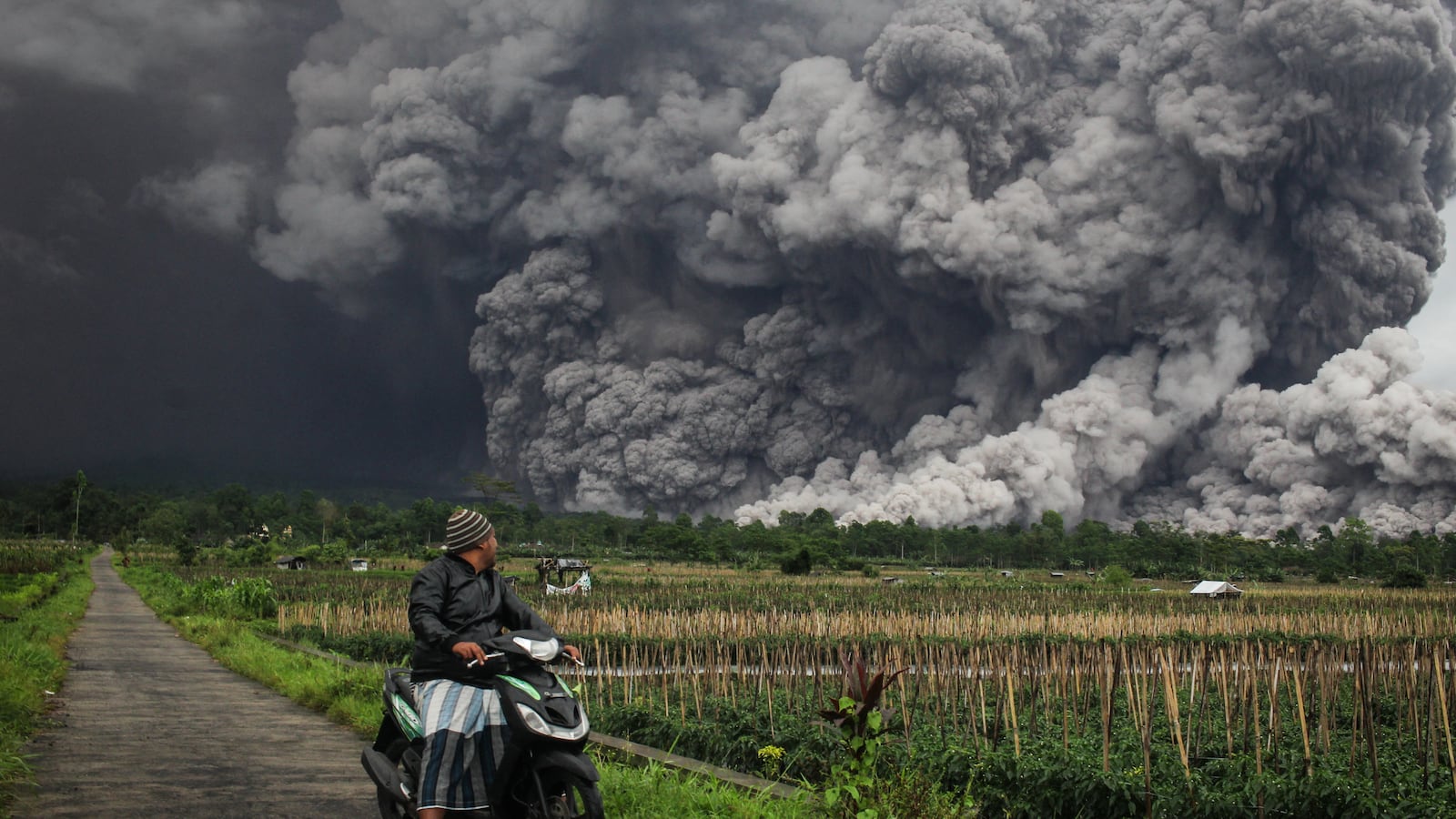 A man looks at a pyroclastic flow during the eruption of Mount Semeru.