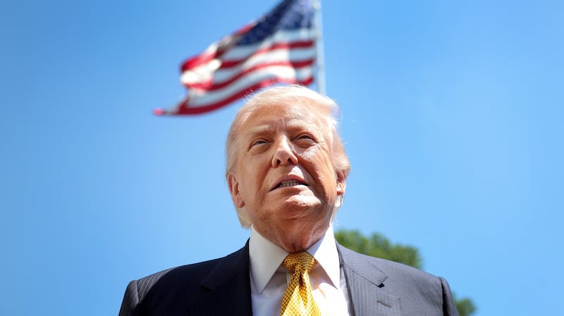 President Donald Trump speaks in front of the American flag to the press as he departs the White House on May 12, 2026 in Washington, DC.