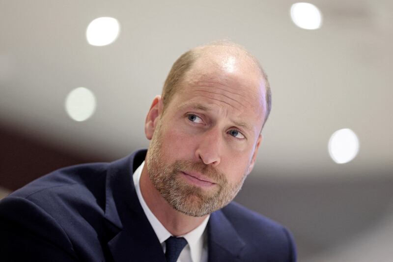 Prince William looks on as he interacts with Jac's family members and teammates from Jac’s football team Ammanford FC during his visit to new a mental health hub run by the Jac Lewis Foundation on World Suicide Prevention Day.