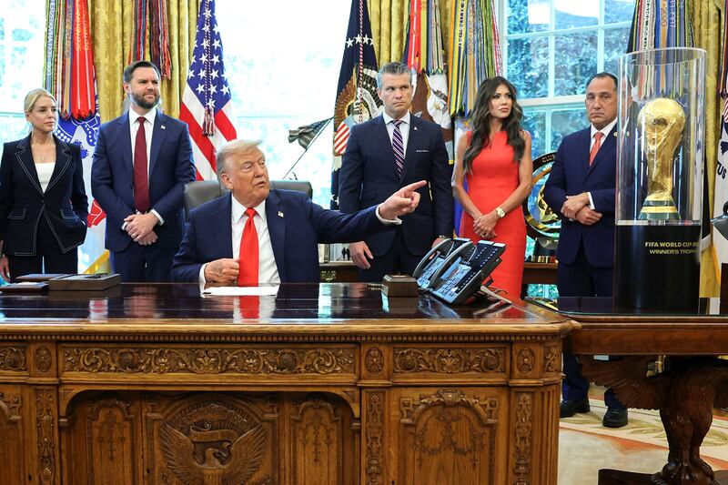 President Donald Trump points to the FIFA World Cup Trophy during an event in the Oval Office to sign an executive order, at the White House in Washington, D.C. on Aug. 25, 2025.