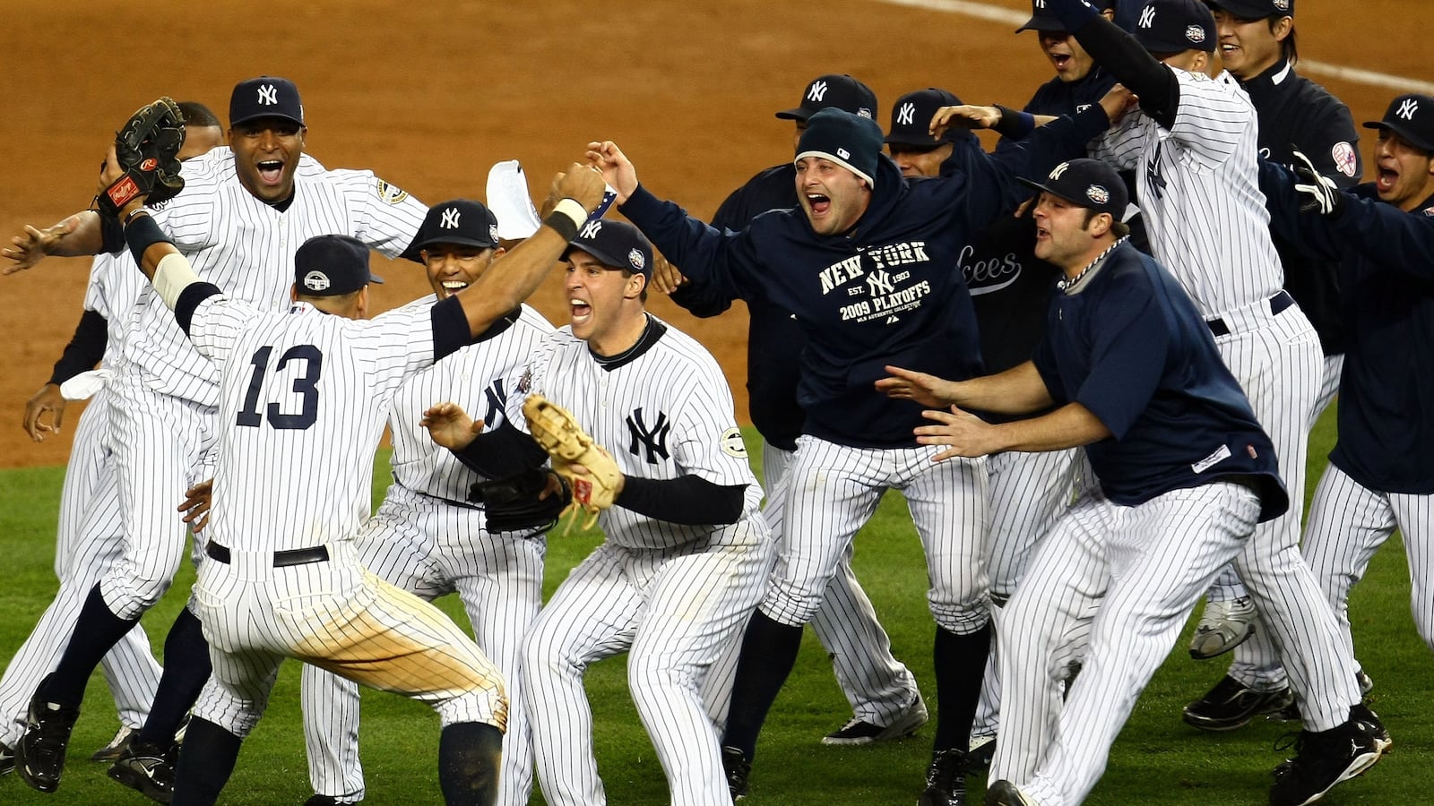 Mariano Rivera #42 and Mark Teixeira #25 of the New York Yankees run towards Alex Rodriguez #13 and his teammates as they celebrate after their 7-3 win against the Philadelphia Phillies in Game Six of the 2009 MLB World Series at Yankee Stadium on November 4, 2009 in the Bronx borough of New York City.