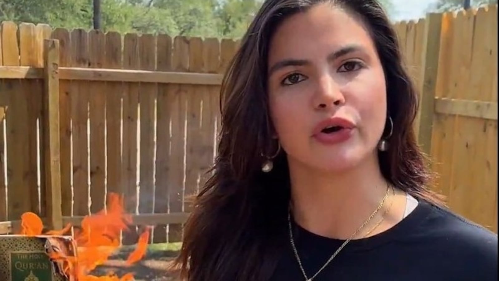 Valentina Gomez next to a burning Quran.