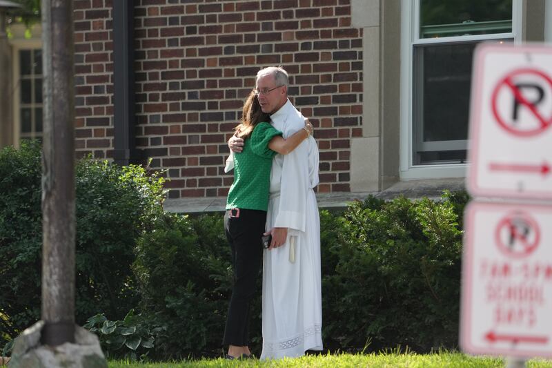 Members of the church comfort one another after a shooting at Annunciation Catholic Church on Wednesday morning, August 27, 2025 in Minneapolis.