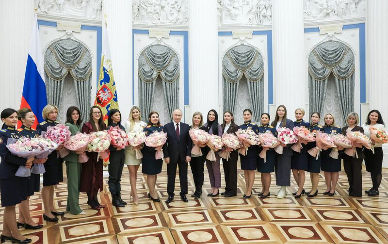 Russian President Vladimir Putin poses for a picture with women during a meeting dedicated to the upcoming International Women's Day at the Kremlin in Moscow, Russia March 5, 2026.