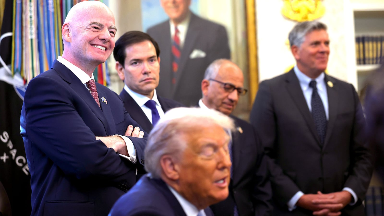FIFA President Gianni Infantino (L) and U.S. Secretary of State Marco Rubio listen as U.S. President Donald Trump delivers remarks