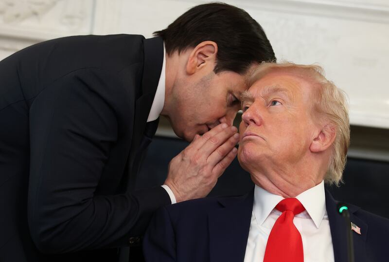 Secretary of State Marco Rubio (L) speaks to U.S. President Donald Trump during a roundtable discussion in the State Dining Room of the White House on October 08, 2025 in Washington, DC.