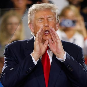 U.S. President Donald Trump puts his hands to his face, as he delivers remarks on the economy, at the General Motors Proving Ground in Milford, Michigan, U.S. July 27, 2026.  REUTERS/Carlos Osorio
