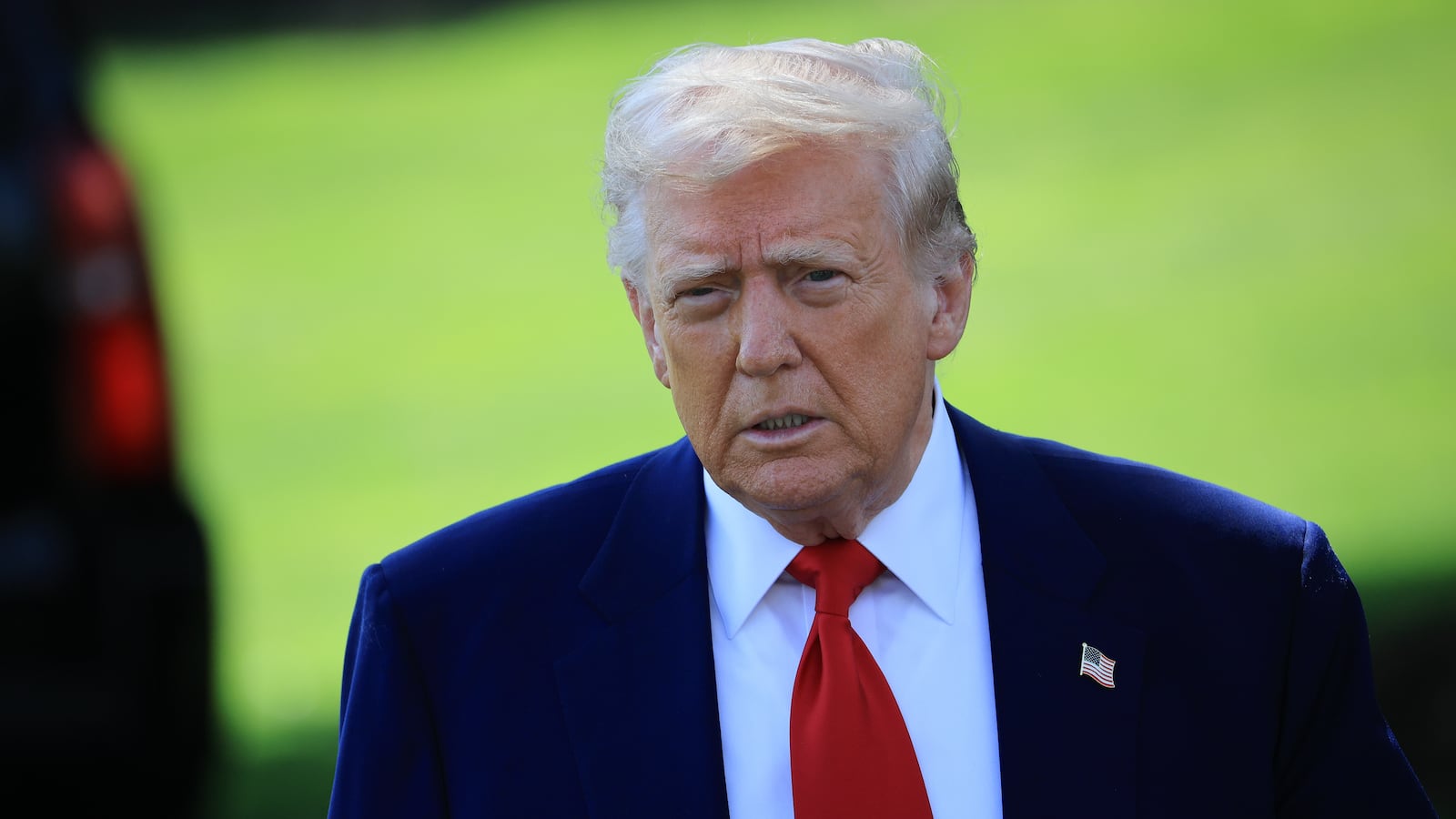 U.S. President Donald Trump walks toward members of the media.
