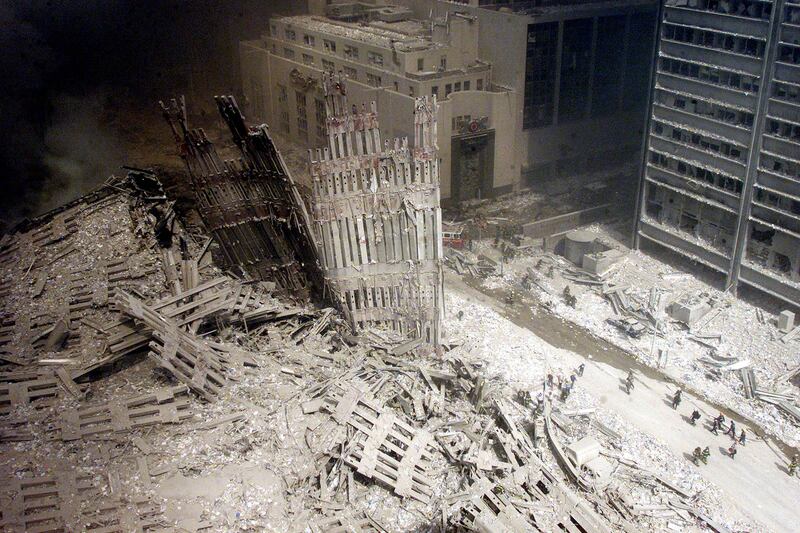 A group of firefighters walk amid rubble near the base of the destroyed
south tower of the World Trade Center.