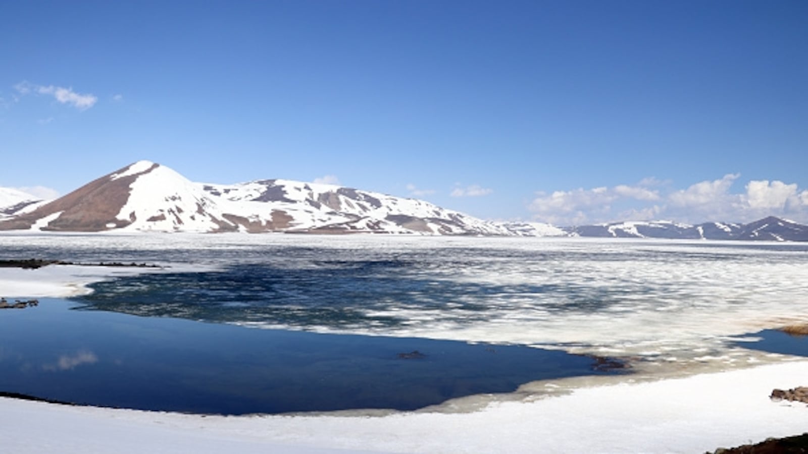 AGRI, TURKIYE - MAY 01: A view of high-altitude Balik Lake in Agri, which resembles 'Antarctica' in May with its ice-covered surface and snowy mountain scenery in Agri, Turkiye on May 01, 2026. Located in the region where Sinek Plateau and Aras Mountains are situated in the north of Taslicay district, at an altitude of 2,241 meters above sea level, Balik Lake stands out with its natural beauties. The lake, which is among the important tourism centers of the Eastern Anatolia Region with its bird and fish species and islands, was completely covered with ice during the harsh winter season. Beautiful images emerged when the surface of the natural wonder lake, which is covered with ice for half of the year, did not thaw in May. The lake, whose ice melted in early April in previous years, offers winter-like landscapes with the surrounding snowy mountains. (Photo by Abdullah Soylemez/Anadolu via Getty Images)
