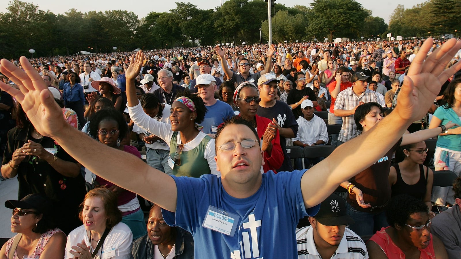 Tomas Rodriguez raises his arms while singing at the Greater New York Billy Graham Crusade June 24, 2005 in the Queens borough of New York. Flushing Meadows Corona Park is the site for Graham's sermons on June 24-26. The Crusade, which looks to draw thousands of people from across the country, will purportedly be the aging Christian televangelist's final crusade.