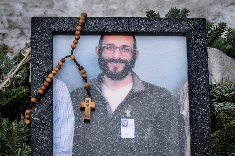 A rosary adorns a framed photo Alex Pretti, who was shot dead by Border Patrol agents.
