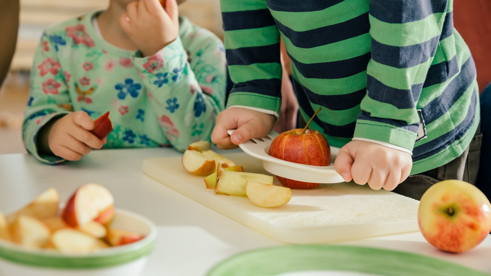 Stock image showing kindergarteners with food.