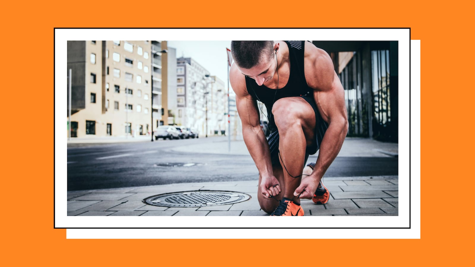 Man tying his shoes on the street.