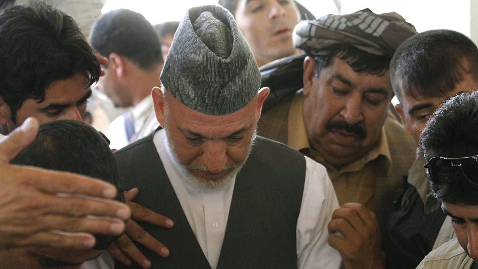 cheats/2011/07/13/karzai-jumps-into-brother-s-grave/karzai-funeral-cheat_tjrne4
