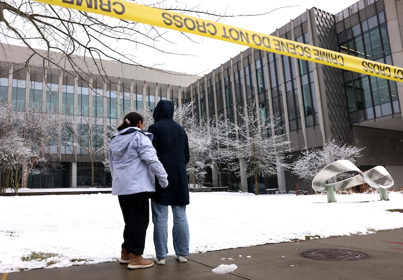 PROVIDENCE, RI - December 14: People pause outside of Barus & Holley School at Brown University where two people were killed and nine people were injured by a gunman on December 14, 2025. (Photo by Jessica Rinaldi/The Boston Globe via Getty Images)