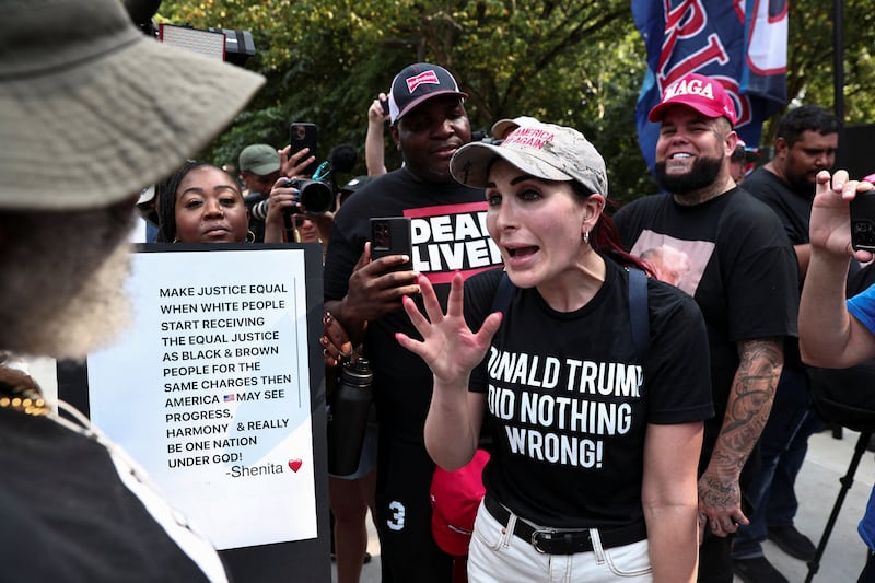 Laura Loomer, far-right activist, speaks with anti-Trump demonstrators near the entrance of the Fulton County Jail in 2023. REUTERS/Dustin Chambers.