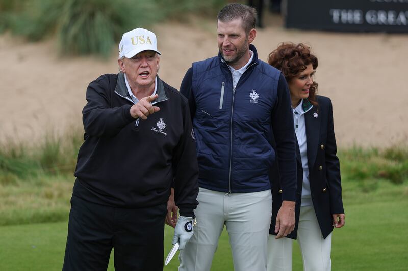 U.S. President Donald Trump cuts the ribbon next to Eric Trump (2nd R) and Sarah Malone, Executive Vice President and general manager of Trump international Golf Links Scotland (R)