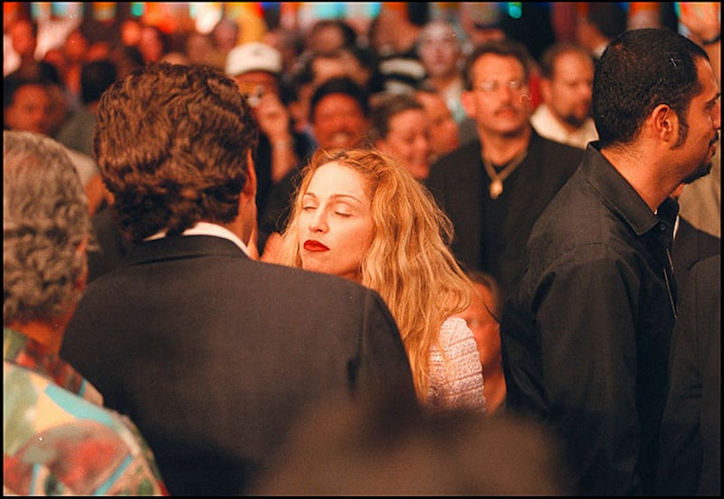 American attorney John F Kennedy Jr (1960 - 1999) (dark jacket, back to camera) and Pop singer Madonna (born Madonna Ciccone) talk together at the MGM Grand Garden Arena, Paradise, Nevada, June 28, 1997.