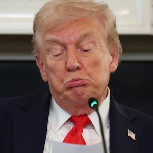 President Donald Trump reads a note in the State Dining Room of the White House on October 08, 2025 in Washington, DC.