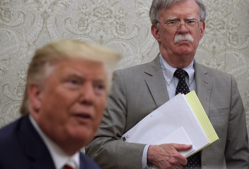 President Donald Trump speaks to members of the media as John Bolton listens in the Oval Office of the White House on August 20, 2019 in Washington, DC.