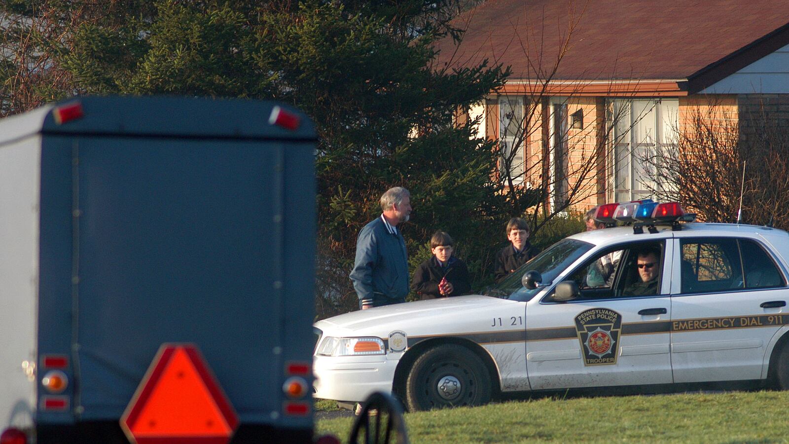 Amish children pass Pennsylvania state troopers.