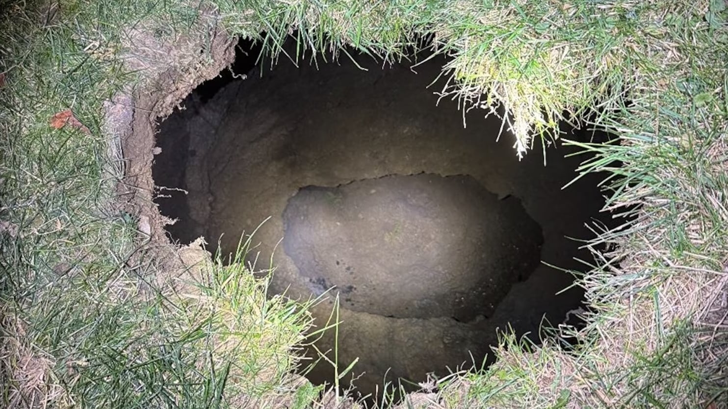 A sinkhole surrounded by grass.