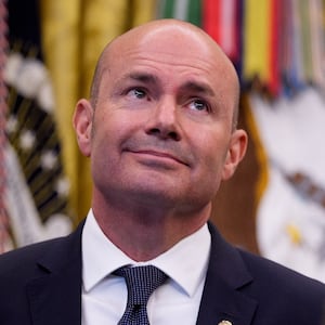 Sen. Mike Lee (R-UT) (L), and Utah Gov. Spencer Cox (R) stand behind U.S. President Donald Trump (C) as he speaks to members of the media during an executive order signing in the Oval Office of the White House on July 13, 2026 in Washington, DC. Trump signed two executive orders related to the transfer of federal land to the State of Utah.