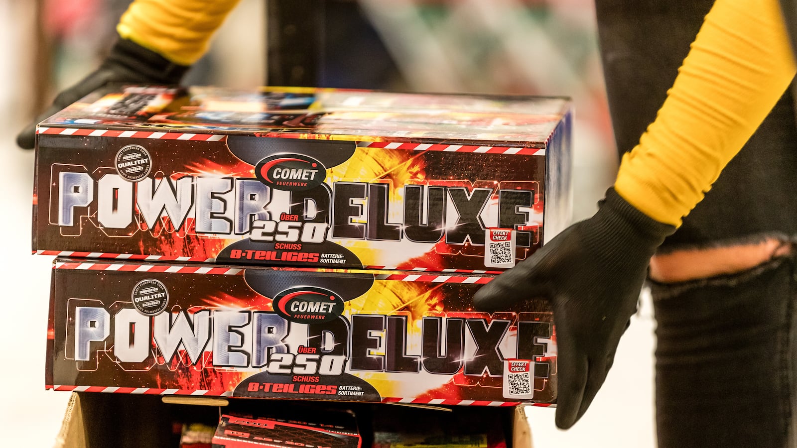 A supermarket saleswoman takes fireworks from a pallet