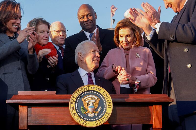  U.S. President Joe Biden celebrates with lawmakers including then-House Speaker Nancy Pelosi
