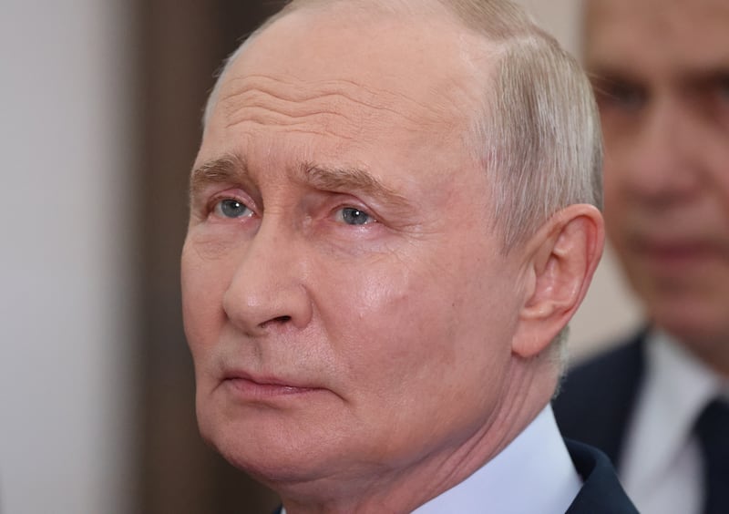 Russian President Vladimir Putin observes an exhibition
