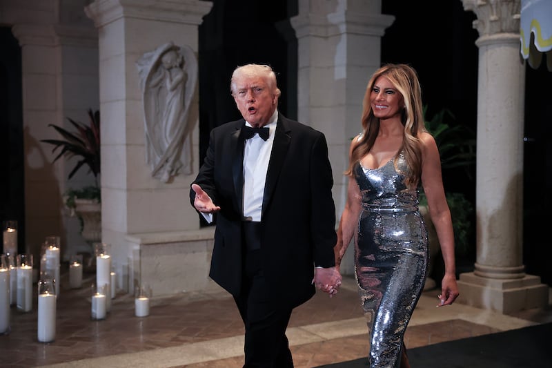 PALM BEACH, FLORIDA - DECEMBER 31: U.S. President Donald Trump and first lady Melania Trump arrive for a New Year’s Eve event at his Mar-a-Lago home on December 31, 2025 in Palm Beach, Florida. The president addressed guests and celebrated the arrival of 2026. (Photo by Joe Raedle/Getty Images)