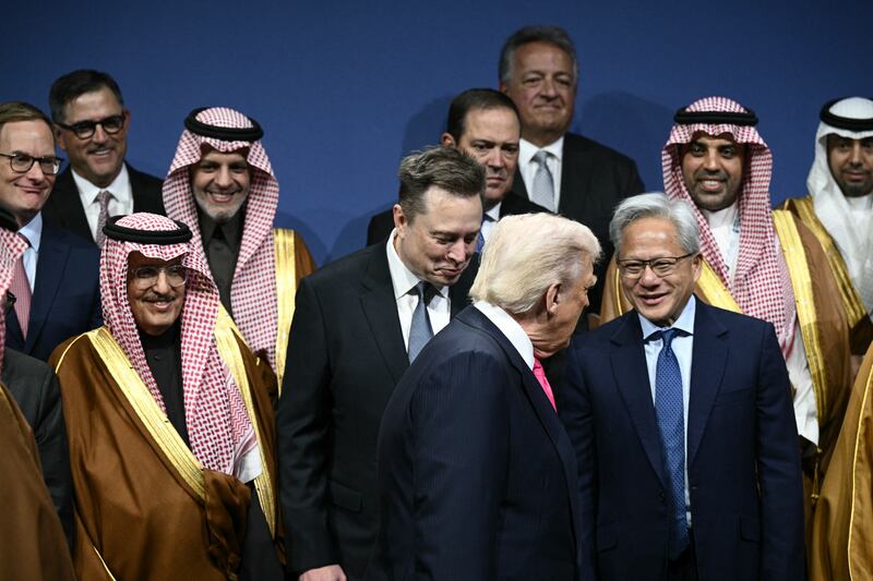 US President Donald Trump, Elon Musk (C), Nvidia founder and CEO Jensen Huang (R) and other attendees, arrive for a family picture the US-Saudi Investment Forum at the John F. Kennedy Center for the Performing Arts in Washington, DC on November 19, 2025.