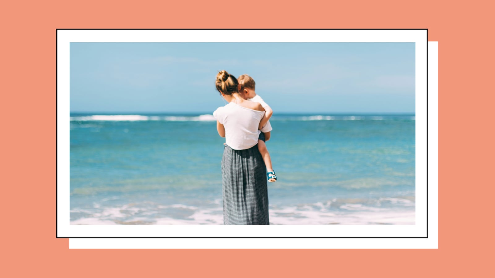 A mother carries her young child on her hip, both facing away toward a calm turquoise ocean on a sunny day. Framed like a Polaroid photo on a coral-pink background.